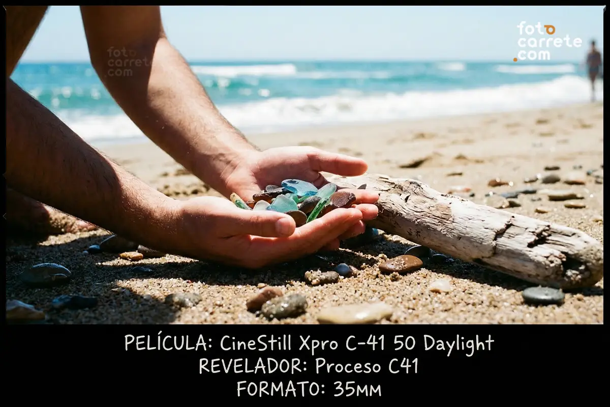 Manos sosteniendo cristales de mar de colores en la playa, fotografía con CineStill 50 Daylight.