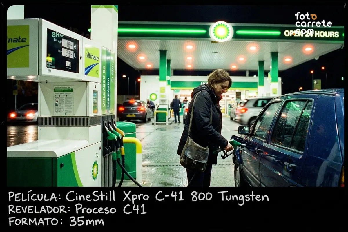 Mujer repostando en una gasolinera iluminada de noche, tomada con película CineStill 800T.