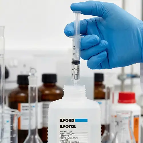 Midiendo dosis exacta de humectante fotográfico con jeringuilla para tanque de revelado.