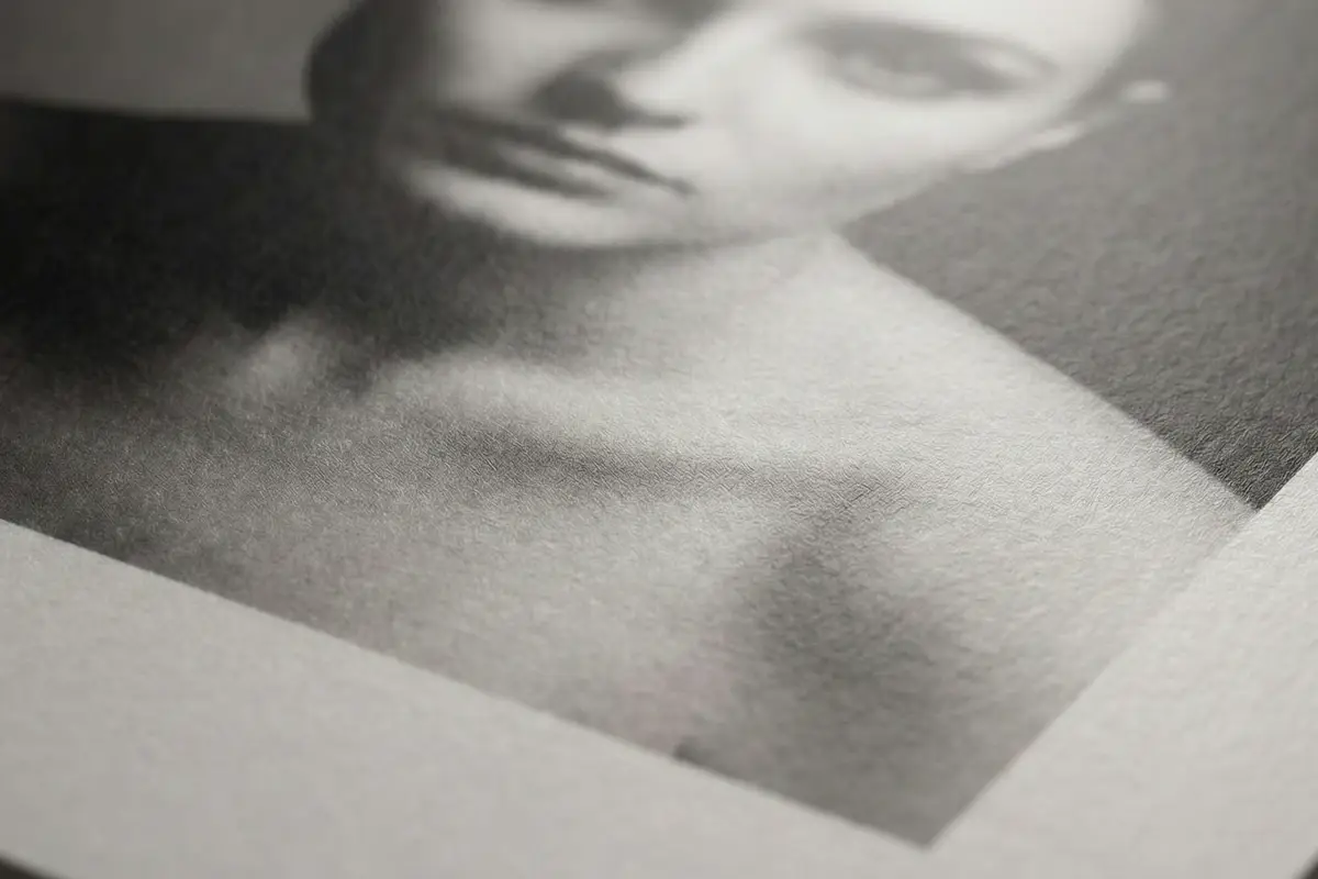 Primer plano de la superficie del papel Ilford Multigrade RC Satin 25M, acabado satinado mate con textura suave para retratos.