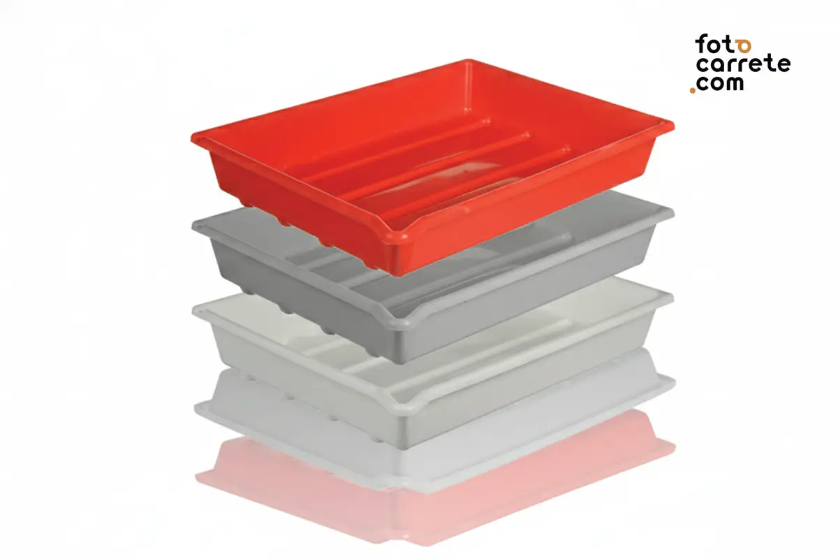 Cubetas de revelado fotográfico apiladas en colores rojo, gris y blanco