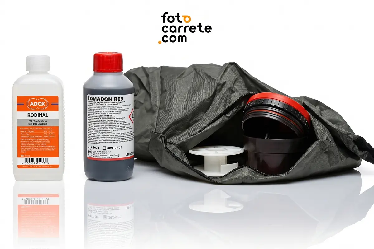 Kit de revelado analógico mostrando químicos Adox Rodinal y Fomadon R09 junto a un tanque de espirales y saco oscuro.