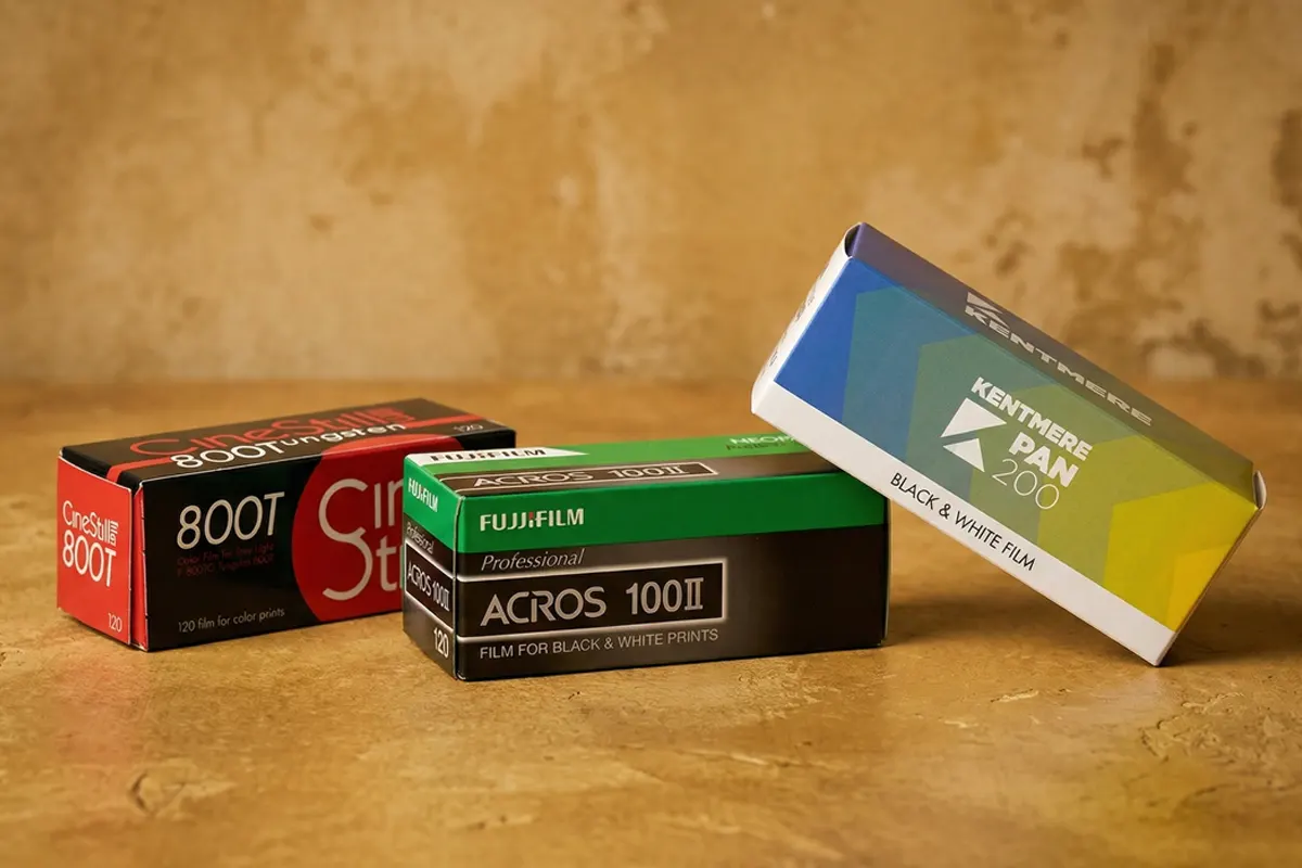 Cajas de película de formato medio 120: CineStill 800T, Fujifilm Acros 100II y Kentmere Pan 200 apoyadas sobre una superficie de madera.