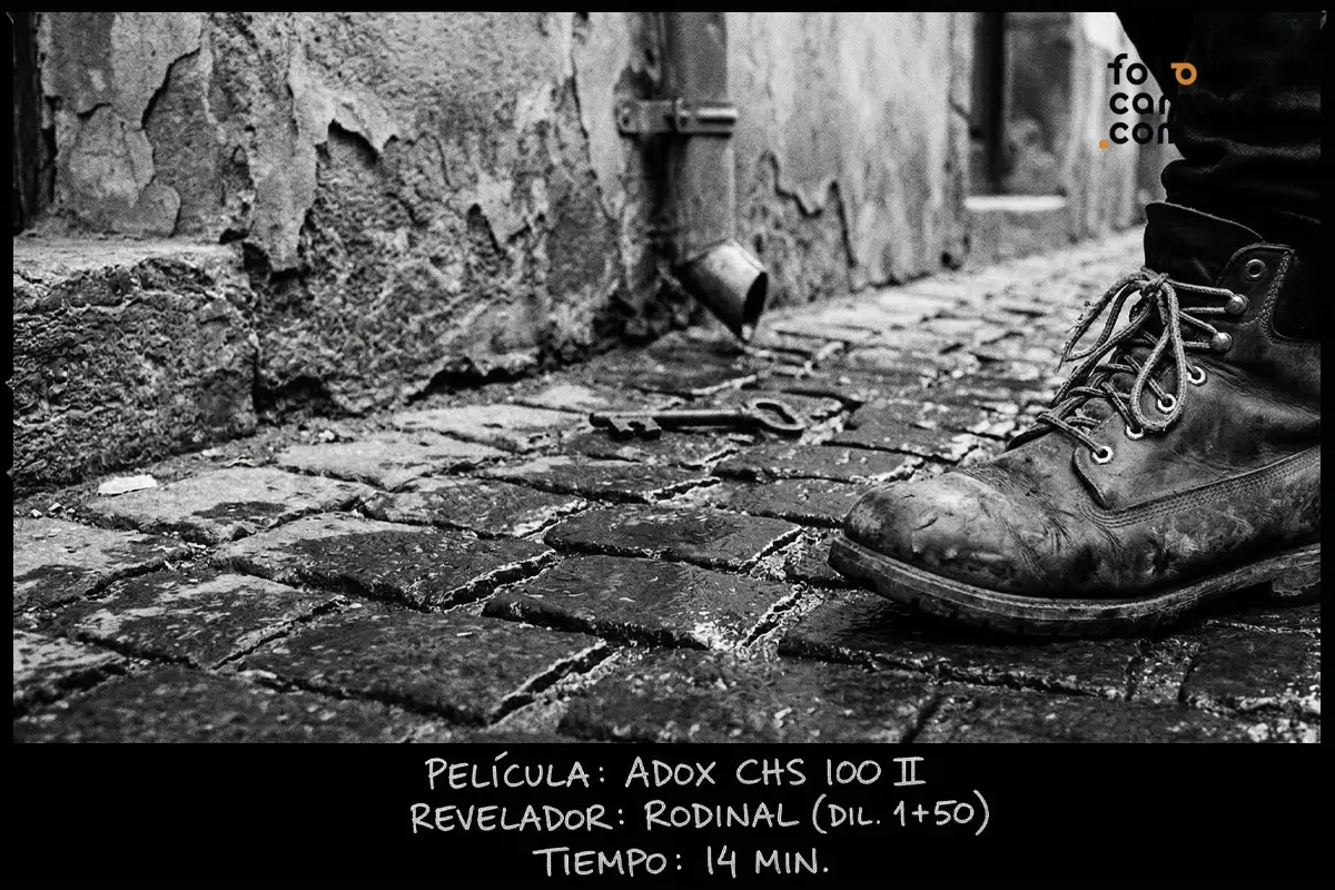 Detalle urbano de bota y llave en suelo empedrado, tomado con carrete Adox CHS 100 II y revelado con Rodinal.