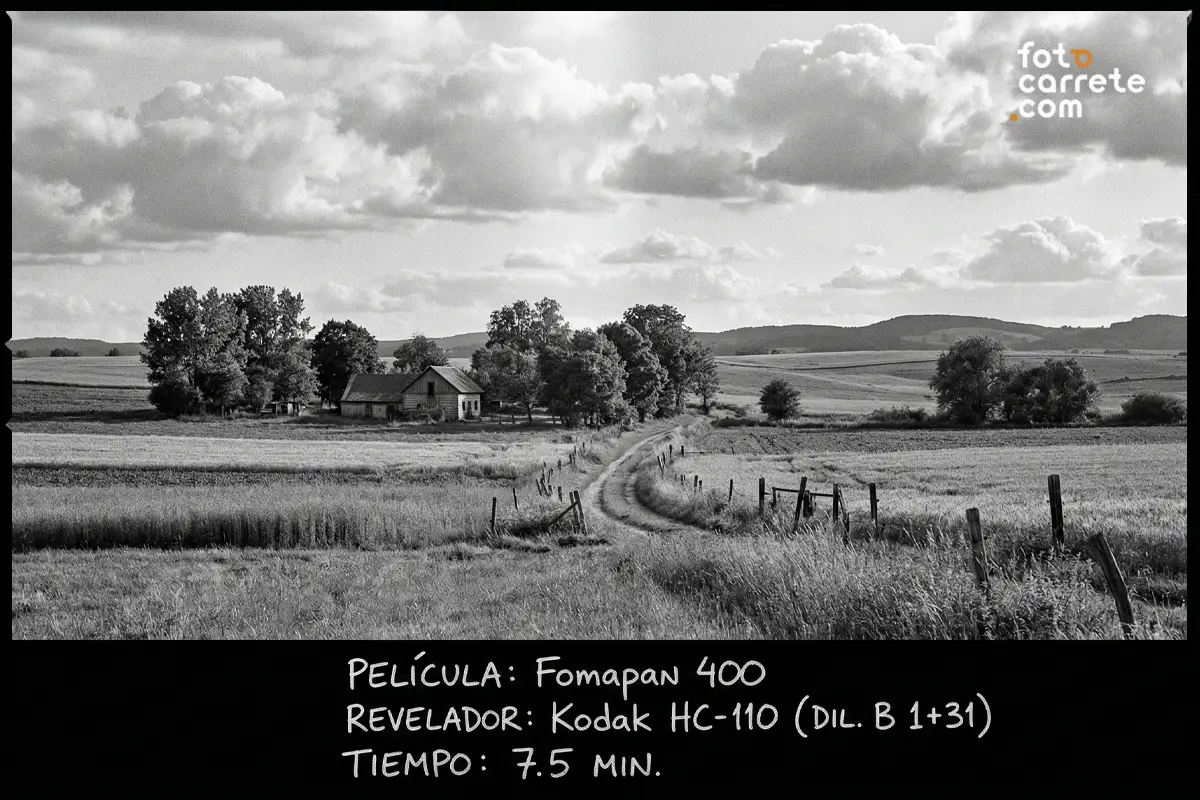 Paisaje rural con camino de tierra y casa de campo capturado con película fotográfica Fomapan 400 y Kodak HC-110.
