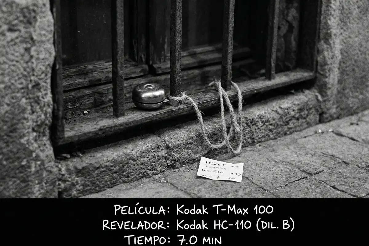 Fotografía urbana de ventana con rejas y campana, tomada con película Kodak T-Max 100 y revelada con HC-110.