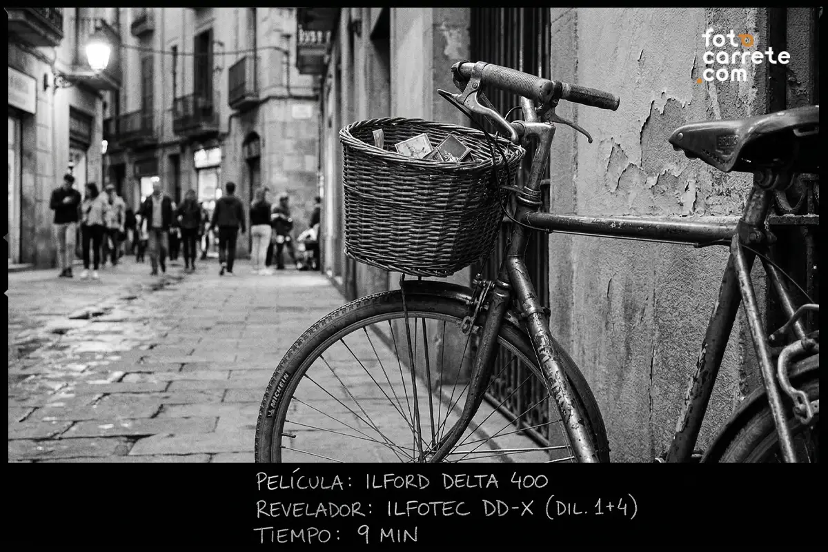 Fotografía callejera de bicicleta con cesta en la ciudad, tomada con Ilford Delta 400 y revelador Ilfotec DD-X.