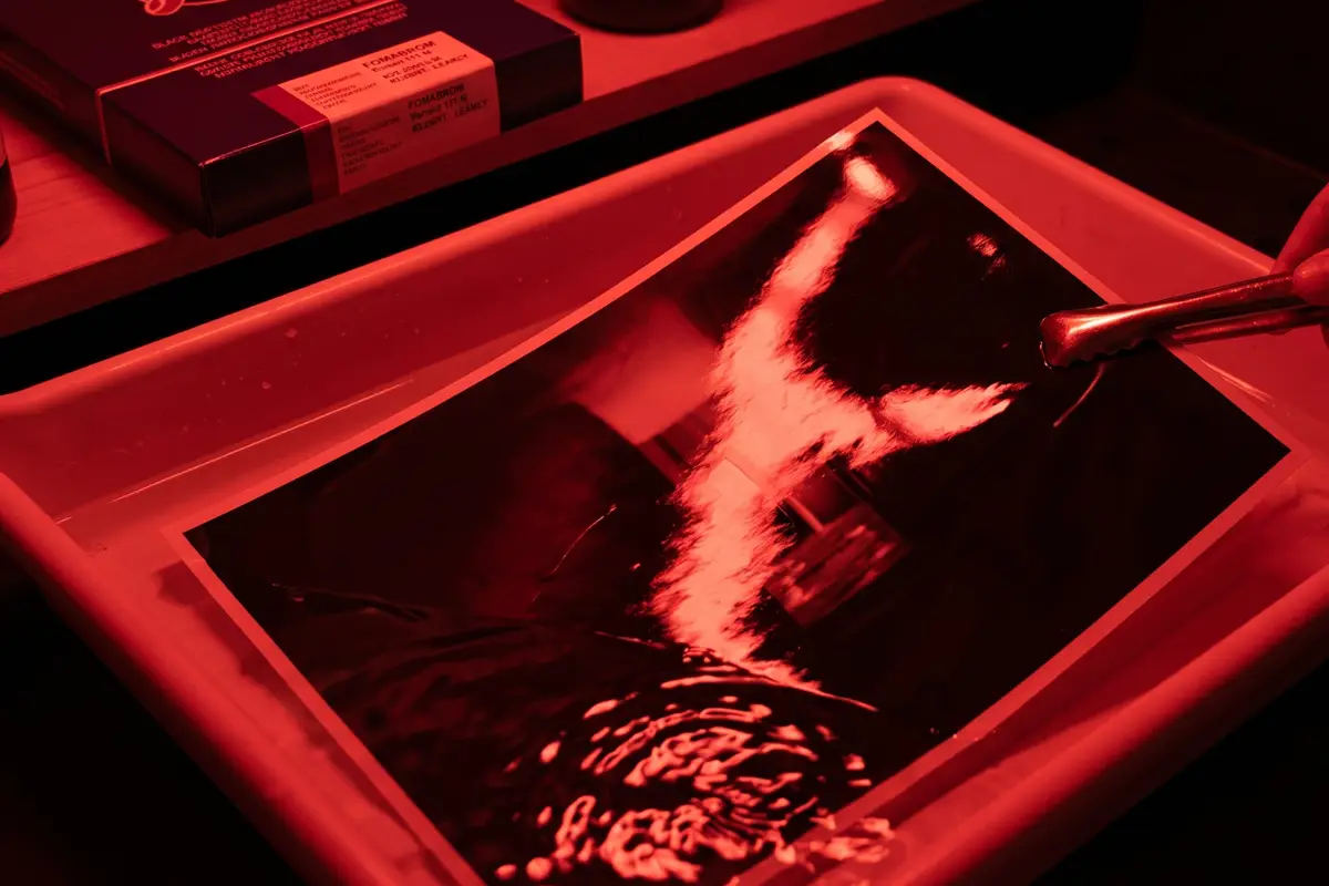 Proceso de revelado de fotografía en papel Fomabrom N brillo bajo luz inactínica roja.