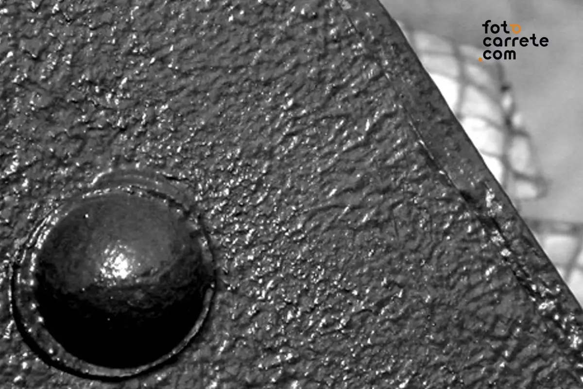 Detalle de textura metálica y remache impreso en papel Fomabrom chamois.